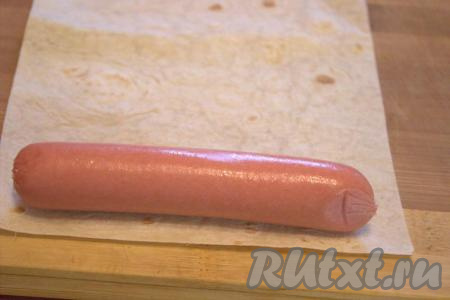 Сосиски очистить от плёнки. Лаваш развернуть, отрезать от лаваша полоску шириной чуть больше длины сосиски (как на фото). Если вы для приготовления закуски будете использовать 4 сосиски, значит вам понадобятся 4 длинных полоски лаваша шириной чуть больше длины каждой сосиски.