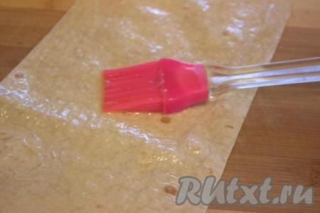 В отдельной миске взбить до однородности яйцо. При помощи силиконовой кисточки смазать каждую полоску из лаваша взбитым яйцом (благодаря смазыванию яйцом, лаваш станет мягким и пластичным).