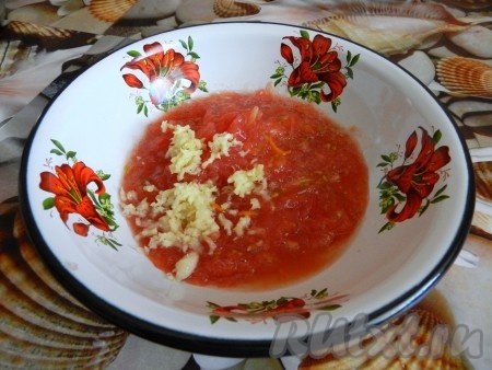 Подготовим овощной соус. Для этого помидор нужно вымыть, натереть на крупной тёрке так, чтобы кожура осталась в руках. Кожуру выкинуть. Зубчики чеснока натереть на мелкой тёрке (или пропустить через пресс), добавить к натёртым помидорам.