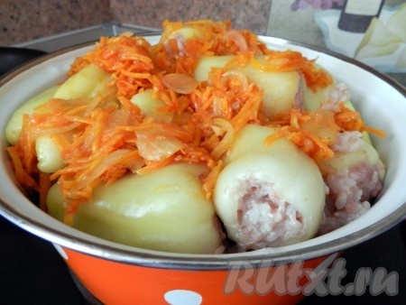 Болгарский перец, фаршированный мясом и рисом,&nbsp;выложить в большую кастрюлю вместе с подготовленным овощным соусом. Влить в кастрюлю с перцами столько воды, чтобы вода заполняла кастрюлю не менее чем на половину, поставить на достаточно сильный огонь, довести до кипения.