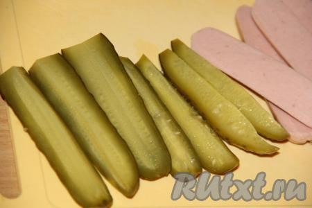 Огурчики нарезать на брусочки. Лучше брать огурчики такой же длины, как и длина сосисок.