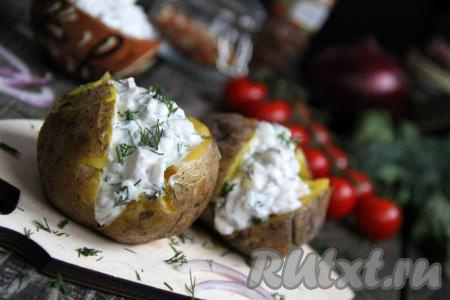 Слегка сжать картофелину, чтобы мякоть разрыхлилась. В разрез на поверхности каждого клубня выложить соус из селёдки, солёных огурцов и лука. Наивкуснейшую запечённую фаршированную картошку подать к столу в горячем виде. 