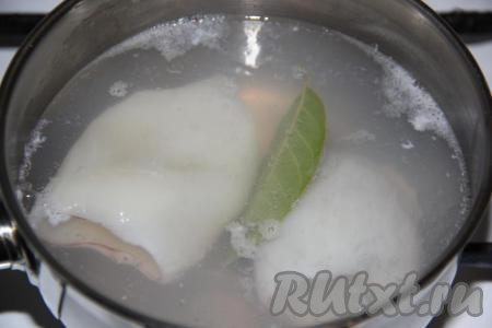 Воду влить в кастрюлю, по желанию, добавить лавровый лист. Когда вода хорошо закипит, опустить тушки кальмаров. Я опускаю в воду по одной или две тушки. Варить 10 секунд, достать тушки кальмаров и дать воде снова хорошо закипеть. Затем добавить следующие 1-2 тушки и тоже варить 10 секунд. Аналогично сварить всех кальмаров.