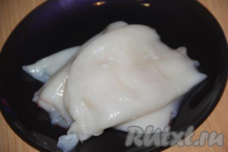 Кальмары предварительно разморозить при комнатной температуре. Промыть под водой. Я купила очищенные кальмары. Неочищенные кальмары нужно очистить от тёмной плёнки, а затем удалить хорду из каждой тушки.