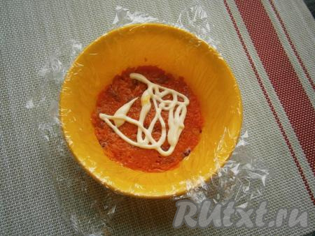 Следующим слоем выложить половину моркови с курагой, утрамбовать, смазать майонезом. 