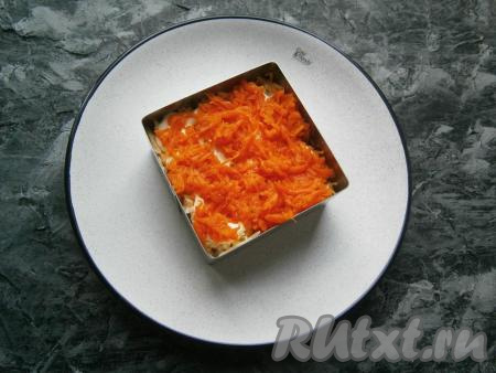 Варёная морковка, натёртая на средней тёрке, станет следующим слоем. Морковь чуть посолить, смазать майонезом.
