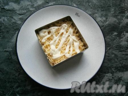 Следующим слоем выложить сыр, натёртый на мелкой тёрке, хорошо смазать майонезом.