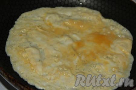 Влить в сковороду немного растительного масла, разогреть, затем вылить взбитое яйцо. Равномерно распределить яичную массу по поверхности сковороды, жарить блинчик на среднем огне.