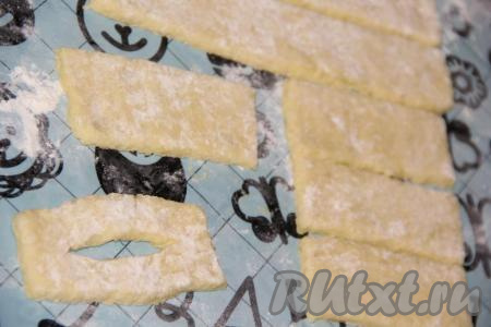 Раскатать картофельное тесто на поверхности, припылённой мукой, в пласт толщиной, примерно, 1 см. Нарезать картофельный пласт на полоски длиной 15 см и толщиной&nbsp;3 см. В середине каждой полоски сделать разрез.