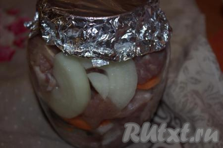 Горлышко банки с мясом и овощами накрыть двойным слоем фольги. Банку со свининой поставить на противень (или в форму для запекания) и отправить в холодную (!) духовку. Выставить температуру 180 градусов на 2 часа. По истечении указанного времени духовку выключить и дать банке немного остыть (иначе от перепада температуры банка может лопнуть). Затем, достав банку из духовки, лучше поставьте её на деревянную дощечку, тогда стекло точно не лопнет.