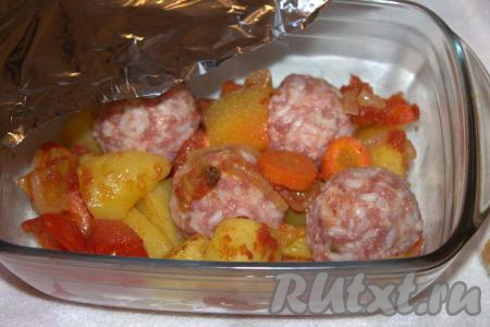 Жаропрочную форму с тефтелями и овощами накрыть фольгой (или крышкой), поставить в разогретую духовку и запекать 40-45 минут при температуре 180 градусов. 