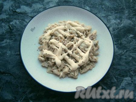 На круглую плоскую тарелку выложить нарезанное мясо курицы первым слоем, немного посолить, нанести сеточку из майонеза, поперчить.