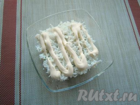 Отварить яйца в течение минут 10 с момента закипания воды, затем дать остыть, очистить и отделить желтки от белков. Натереть белки на средней тёрке и выложить их на слой киви, немного подсолить и смазать майонезом.