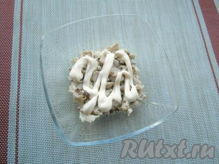 Куриное мясо отварить в подсоленной воде в течение 30-40 минут с момента закипания, остудить и нарезать кусочками. Выложить курицу в салатник первым слоем, немного посолить, смазать майонезом.