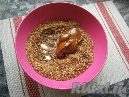 Печенье с орехами пересыпать в миску, влить растопленное сливочное масло, добавить варёную сгущенку.