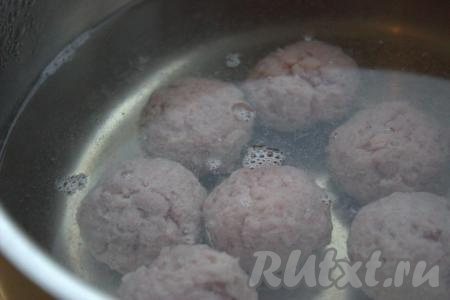 В кипящую воду опустить подготовленные фрикадельки и снова довести воду до кипения. Уменьшить огонь до среднего и дать провариться фрикаделькам, примерно, 5-7 минут. Образовавшуюся при закипания пену снять при помощи шумовки.