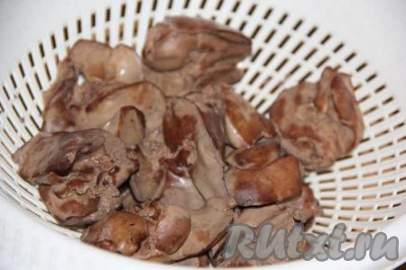 Откинуть варёную куриную печень на дуршлаг и дать стечь воде.