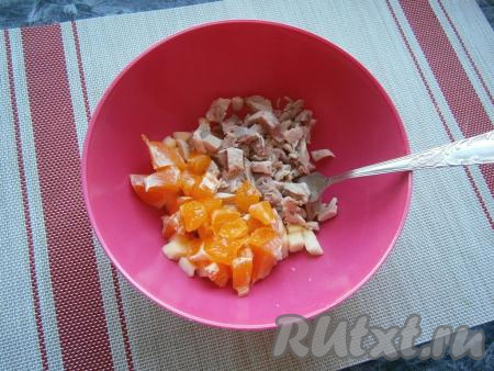 Предварительно отварить курицу в течение 40-45 минут в подсоленной воде, убрать кости, остудить и нарезать кусочками. К яблокам добавить нарезанное куриное мясо. Мандарины очистить, удалить белые волокна, каждую дольку разрезать на 2-3 части, добавить в салат из курицы и яблока.