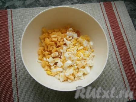 Порубить яйца ножом (не мелко). Добавить в салатник рубленные яйца и нарезанный маленькими кубиками сыр.