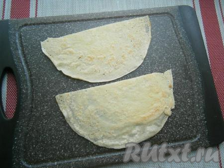 После того как мы пожарили все блинчики, их можно сразу подать на стол, дополнив, например, сметаной или вареньем. Я же решила подать блины с красной икрой. Для такой подачи нужно каждый блинчик разрезать пополам.