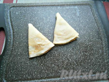 Сложить блины треугольниками. Таким образом нафаршировать все блинчики красной икрой.