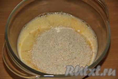 В миску вбить яйца, добавить молоко и слегка взбить венчиком. Затем всыпать измельчённые овсяные хлопья.