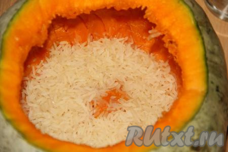 Слить из тыквы воду. На дно всыпать немного риса.