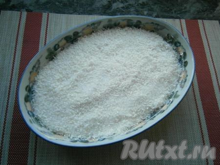 Засыпать тесто полностью смесью кокосовой стружки и сахара, аккуратно разровнять.