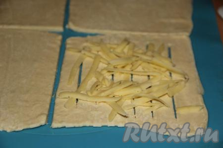 Сыр натереть на тёрке и выложить на тесто.