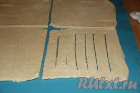 Разрезать раскатанный пласт&nbsp;теста&nbsp;на 4 одинаковых квадрата (это наши 4 заготовки, из одного пласта теста мы получаем&nbsp;4 сосиски в тесте).&nbsp;На каждом&nbsp;маленьком квадрате сделать 5-6 надрезов, но не дорезая до края&nbsp;(как на фото).