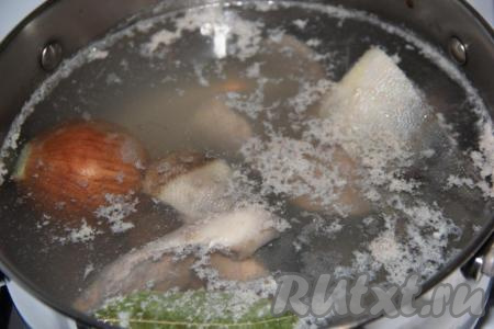 Одну луковицу, не очищая, промыть под проточной водой. Как только уха закипит, снять с бульона пенку и добавить в кастрюлю неочищенную луковицу и лавровый лист, затем после закипания убавить огонь. Варить рыбный бульон в течение&nbsp;20 минут на небольшом огне.