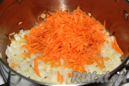 Обжарить лук, периодически помешивая, до мягкости (в течение 3 минут) на среднем огне, затем добавить очищенную и натёртую на крупной тёрке морковку.