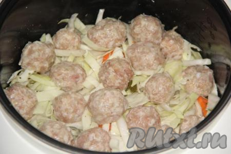 Сформировать круглые фрикадельки и выложить их на капусту в чашу мультиварки.