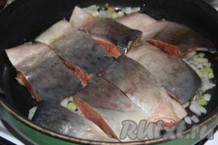 Выложить кусочки горбуши на лук и жарить с одной стороны на среднем огне, примерно, 5 минут.