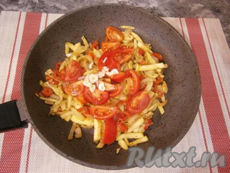 Добавить в сковороду помидоры черри, разрезанные на 2-4 части (или обычный помидор, нарезанный на дольки) и измельчённый чеснок.