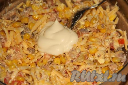 Слегка посолить салат из сыра, помидоров, яиц, рыбных консервов и кукурузы, добавить майонез.