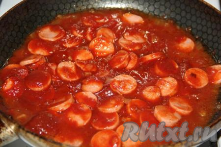 Перемешать сосиски с томатным соусом и потомить на небольшом огне 3-4 минуты. Добавить любые специи, перемешать.