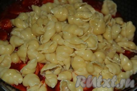 На сковороду к сосискам добавить отваренные макароны.