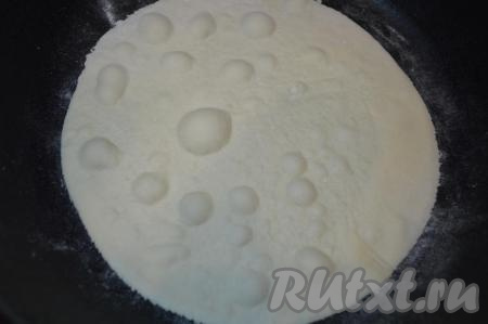 Сухую сковороду хорошо разогреть. Выложить раскатанный и обрезанный корж на хорошо разогретую сковороду. Жарить на среднем огне до золотистого цвета вначале с одной стороны (когда на поверхности коржа появятся вздутия, как на фото, посмотрите, возможно, пора переворачивать).