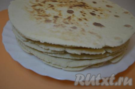 Готовый корж переложить со сковороды на тарелку. Таким образом раскатать и пожарить все коржи, складывая их стопочкой на тарелку. У нас получится 8 коржей. Тесто, оставшееся после обрезания раскатанного теста, слепить в шарик, раскатать и тоже пожарить на сковороде - этот корж в дальнейшем измельчим и будем использовать для посыпки готового торта.