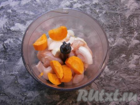 Кусочки куриного мяса выложить в чашу блендера, сюда же добавить нарезанные кусочками лук и морковку.