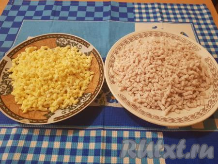 В одну тарелку выложить курицу, пропущенную через мясорубку, в другую - яйца, перекрученные на мясорубке.