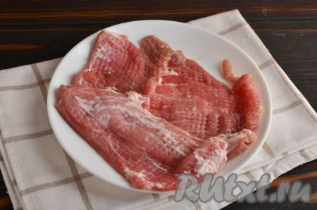 Далее кусочки мяса нужно накрыть пищевой пленкой и отбить с одной стороны кулинарным молотком.