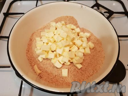 Сверху на сухари выложить заранее нарезанное кусочками сливочное масла (сливочное масло должно быть мягким, поэтому советую за несколько часов до приготовления пирожного достать масло из холодильника).