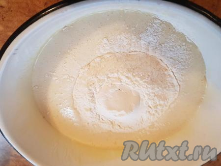 Снять миску с массой с паровой бани и всыпать в неё 2,5 стакана муки.