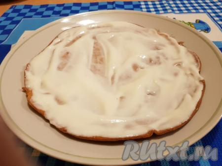 Теперь приступим к сборке "Медовика", для этого на блюдо нужно выложить первый корж и намазать его 3-4 столовыми ложками сметанного крема.&nbsp;