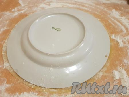 На столе, присыпанном мукой, тонко раскатать одну часть теста и вырезать корж по форме тарелки (у меня диаметр тарелки 23 см). При раскатывании скалка должна быть немного в муке, чтобы не приставала к тесту. Сразу отмечу, из остатков от 8 коржей у меня всегда получается ещё 2-3 дополнительных коржа.