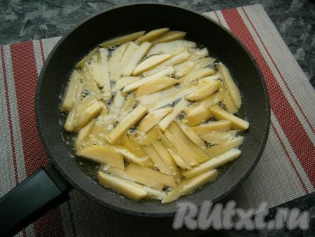 В сковороде (у меня диаметр сковороды 24 см) разогреть 1 стакан подсолнечного масла и выложить картошку так, чтобы она была расположена в один слой.