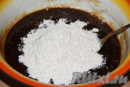 Добавляя небольшими порциями просеянную муку, вначале перемешивать тесто ложкой, затем переложить на стол, припылённый мукой, и хорошо вымесить.