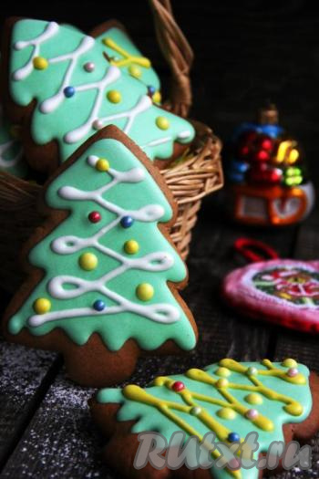 Переложить глазурь (у меня зелёная глазурь) в кулинарный мешок и раскрасить пряники. Глазурь получается средней густоты и хорошо растекается по поверхности пряников. Я сначала делаю контур и оставляю на 10-15 минут, а затем наношу глазурь по всей поверхности. Если делать цветные капельки или полоски поверх уже нанесённой глазури, то нужно подсушить минут 30 глазурь, которая является фоном на пряниках, а затем делать украшение из глазури другого цвета. Пока глазурь не высохла, на неё можно нанести кондитерскую посыпку, сахарные бусинки и т.д. Готовые пряники оставить на 10 часов (до полного высыхания глазури), а затем можно хранить несколько месяцев в большой ёмкости, прикрытой, например, полотенчиком. Рождественские имбирные пряники, украшенные глазурью, получились нарядными, очень вкусными и ароматными, они несомненно не оставят равнодушными ни взрослых, ни детей.